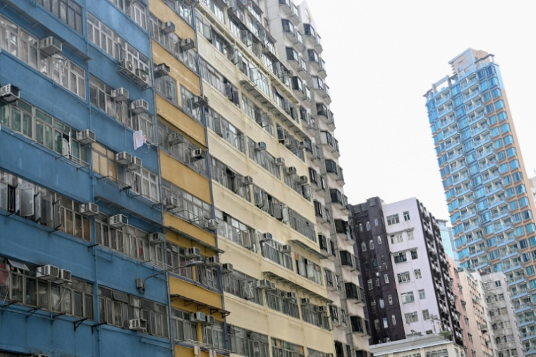 L'immeuble Yee Wa (g) à Cheung Sha Wan, où des habitants vivent dans des logements subdivisés, le 21 mai 2026 à Hong Kong ( AFP / Peter PARKS )