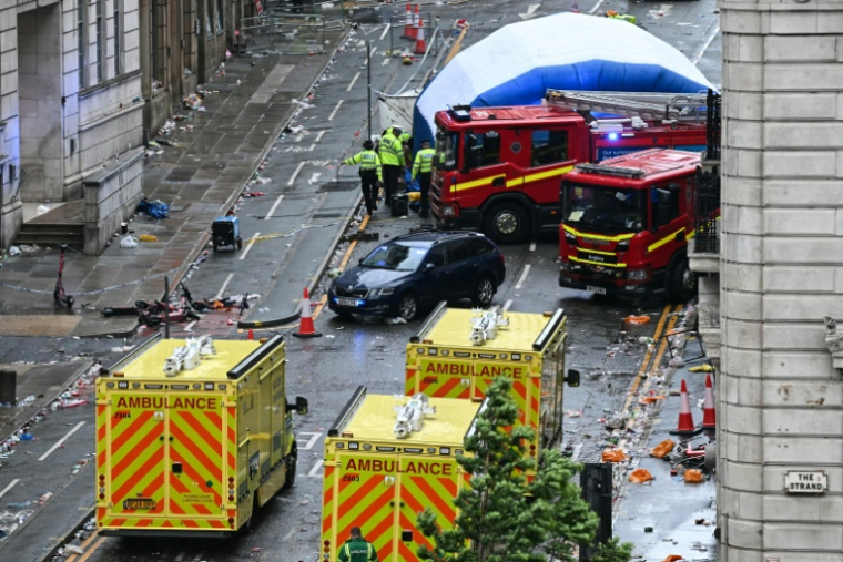 Des policiers couvrent d'une tente gonflable la scène d'un incident à Water Street, en marge d'un défilé pour la victoire de Liverpool en Premier League, à Liverpool, le 26 mai 2025 ( AFP / Paul ELLIS )