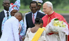 Le pape Léon XIV (à droite) reçoit des fleurs d'enfants alors qu'il est accueilli par le président de Guinée équatoriale Teodoro Obiang Nguema Mbasogo (au centre) à son arrivée à l'aéroport international de Malabo à Malabo le neuvième jour d'un voyage apostolique de 11 jours en Afrique, le 21 avril 2026. ( AFP / Alberto PIZZOLI )