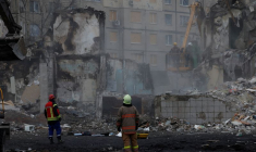 Les services de secours travaillent sur le site où un immeuble d'habitation a été endommagé par un tir de missile russe, à Dnipro