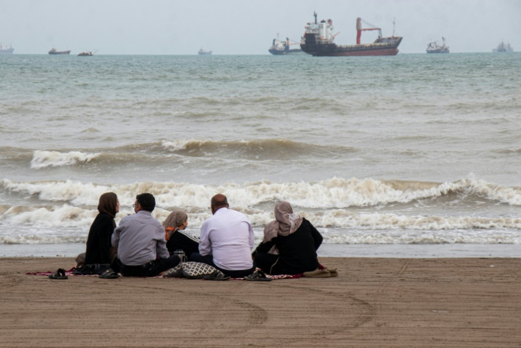 Cette photo diffusée par l'agence de presse iranienne Isna le 24 avril 2026 montre des Iraniens sur une plage bordant le détroit d'Ormuz ( ISNA / RAZIEH POUDAT )