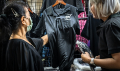 Des clients achètent des vêtements noirs à Bangkok le 30 ocobre 2025 pour porter le deuil après le décès de la reine mère Sirikit,  décédée à 93 ans ( AFP / Chanakarn Laosarakham )