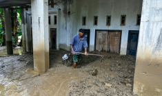 Un homme nettoie l'entrée embourbée d'une maison inondée à Meureudu, dans la province d’Aceh, en Indonésie, le 28 novembre 2025 ( AFP / CHAIDEER MAHYUDDIN )
