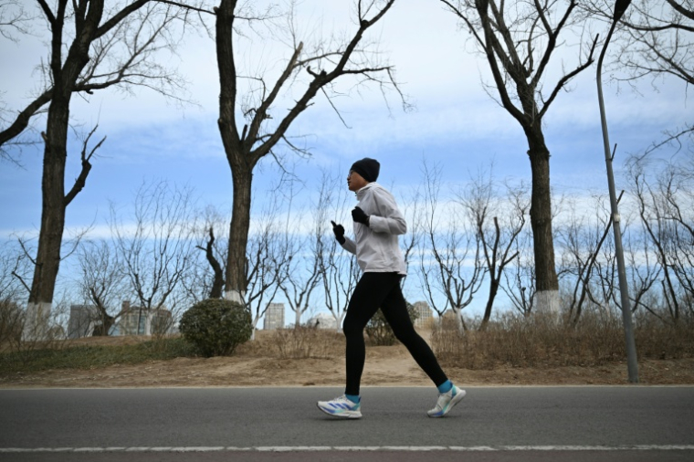 Un joggeur au parc Chaoyang à Pékin, le 5 février 2026 ( AFP / Pedro PARDO )