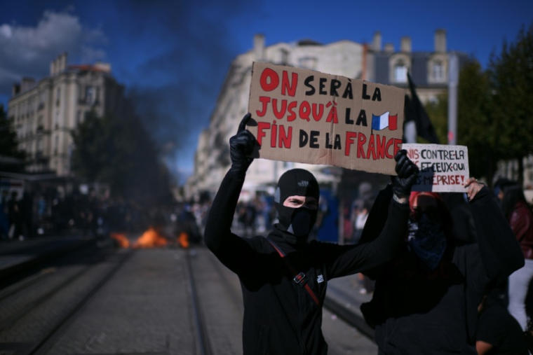 Un jeune cagoulé et vêtu de noir tient une pancarte "On sera là jusqu'à la fin de la France", lors d'une manifestation de lycéens à Bordeaux, le 8 octobre 2026 ( AFP / Christophe ARCHAMBAULT )