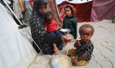 Une Palestinienne nourrit ses enfants devant la tente qui les abrite, à Gaza