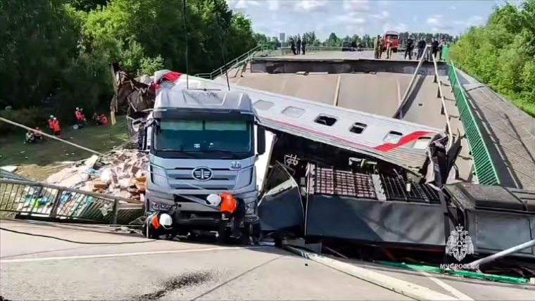 Image tirée d'une vidéo diffusée par le ministère russe des Situations d'urgence, le 1er juin 2025, montrant des secouristes sur le site de l'effondrement d'un pont routier sur une voie ferrée, survenu dans la nuit, faisant dérailler un train de voyageurs, dans la région de Briansk ( Ministère russe des Situations d'urgence / Handout )