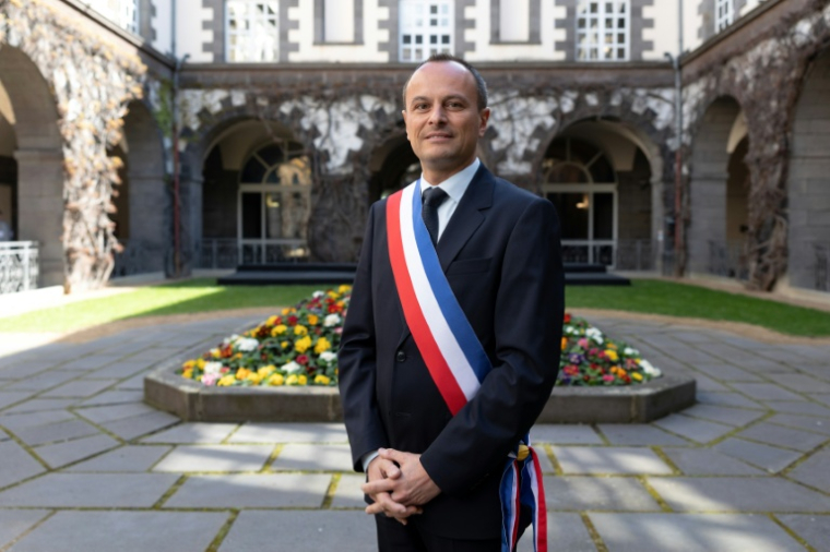 Le maire de Clermont-Ferrand, Julien Bony, ceint de son écharpe tricole, devant la mairie, le 27 mars 2026 dans le Puy-de-Dôme ( AFP / Alex MARTIN )