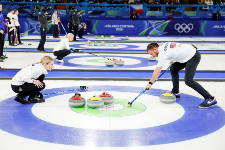 Les Américains Korey Dropkin (d) et Cory Thiesse (g) participent au tournoi de curling en double mixte contre la République tchèque lors des Jeux olympiques d'hiver de Milan-Cortina 2026 au stade olympique de curling de Cortina d'Ampezzo, le 6 février 2026 en Italie ( AFP / Odd ANDERSEN )