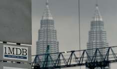 Le logo de 1 Malaysia Development Berhad (1MDB) sur un panneau d'affichage du site de construction de la bourse Tun Razak, à Kuala Lumpur devant les emblématiques tours jumelles de Malaisie. Photo prise le 8 juillet 2015. ( AFP / MANAN VATSYAYANA )