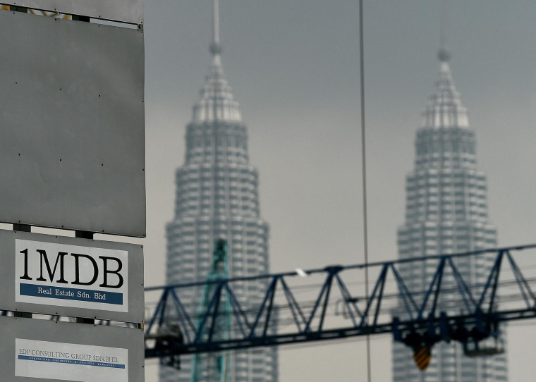 Le logo de 1 Malaysia Development Berhad (1MDB) sur un panneau d'affichage du site de construction de la bourse Tun Razak, à Kuala Lumpur devant les emblématiques tours jumelles de Malaisie. Photo prise le 8 juillet 2015. ( AFP / MANAN VATSYAYANA )