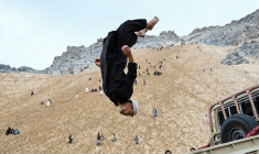 Un Afghan exécute un salto à l'arrière d'un véhicule sur la montagne Reg-e-Rawan dans la région de Sayad, le 24 avril 2026, en Afghanistan ( AFP / Wakil KOHSAR )