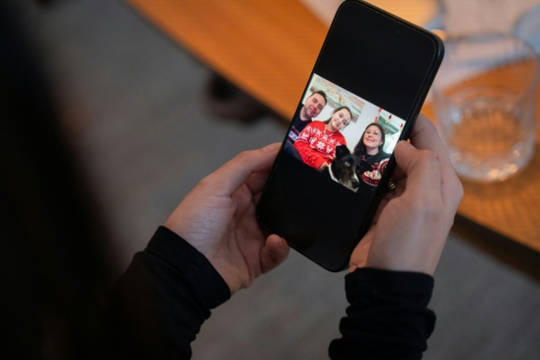 Ulrikke Andersen, une professionnelle de la location touristique, montre une photo de sa famille sur son portable, le 16 janvier 2026 à son domicile de Nuuk au Groenland ( AFP / Alessandro RAMPAZZO )