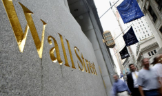 Des personnes marchent le long de Wall Street près de la Bourse de New York