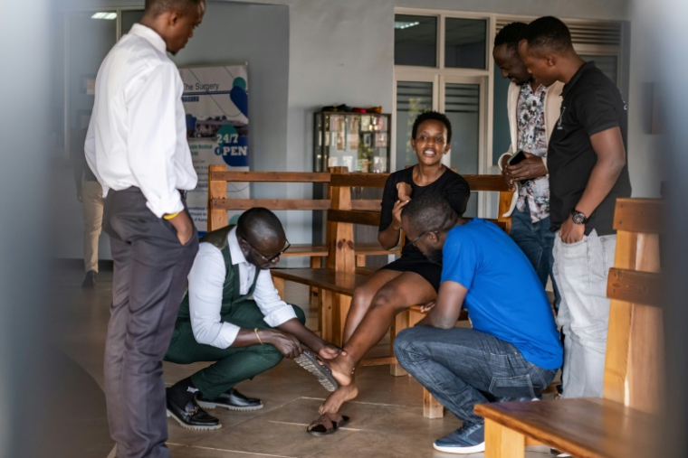 La militante ougandaise des droits humains Agather Atuhaire montre ses bleus et cicatrices à ses collègues après sa détention en Tanzanie, dans un hôpital de Kampala, en Ouganda, le 23 mai 2025 ( AFP / Badru KATUMBA )