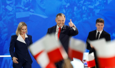Karol Nawrocki, accompagné de son épouse Marta, salue ses partisans après l'annonce des sondages de sortie des urnes, lors du deuxième tour de la présidentielle, le 1er juin 2025 à Varsovie, en Pologne  ( AFP / Wojtek RADWANSKI )