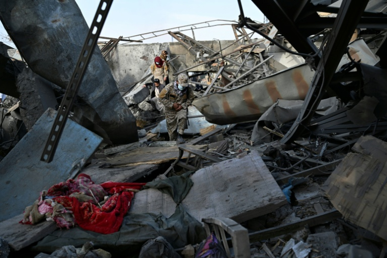 Des membres des forces de sécurité talibanes dans les décombres d'un hôpital pour toxicomanes après des frappes aériennes pakistanaises, le 17 mars 2026 à Kaboul, en Afghanistan ( AFP / Wakil KOHSAR )