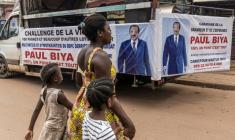 Une femme et ses enfants traversent la rue près d'un camion de campagne du président sortant du Cameroun, Paul Biya, à Yaoundé le 11 octobre 2025 ( AFP / MARCO LONGARI )