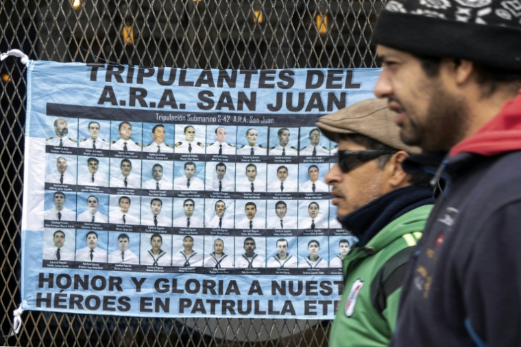Un drapeau argentine avec  les portraits des 44 membres d'équipage qui ont péri lors du naufrage du sous-marin San Juan le 15 novembre 2017 est accroché à l'entrée d'un tribunal de Rio Gallegos, dans la province de Santa Cruz, le 3 mars 2026 ( AFP / WALTER DIAZ )