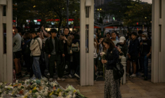Des habitants de Hong Kong déposent des fleurs devant un complexe résidentiel ravagé par un incendie, le 29 novembre 2025 ( AFP / Philip FONG )