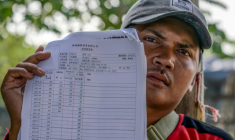 Akhmad, ancien membre d'équipage d'un navire de pêche chinois, montre son contrat et son salaire mensuel lors d'un entretien avec l'AFP au port du hameau de Bungko Lor, à Cirebon, le 10 juin 2026 en Indonésie ( AFP / BAY ISMOYO )