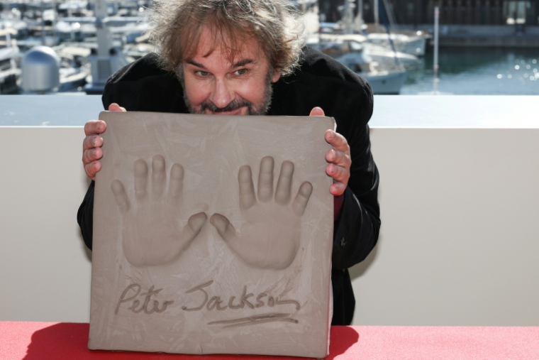 Le réalisateur, scénariste et producteur néo-zélandais Peter Jackson montre ses empreintes de mains lors d'une cérémonie d'intronisation dans le cadre de la 79e édition du Festival de Cannes, à Cannes, dans le sud de la France, le 13 mai 2026 ( AFP / Valery HACHE )