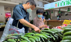 Photo d'archives des clients qui achètent des légumes dans un marché à Pékin