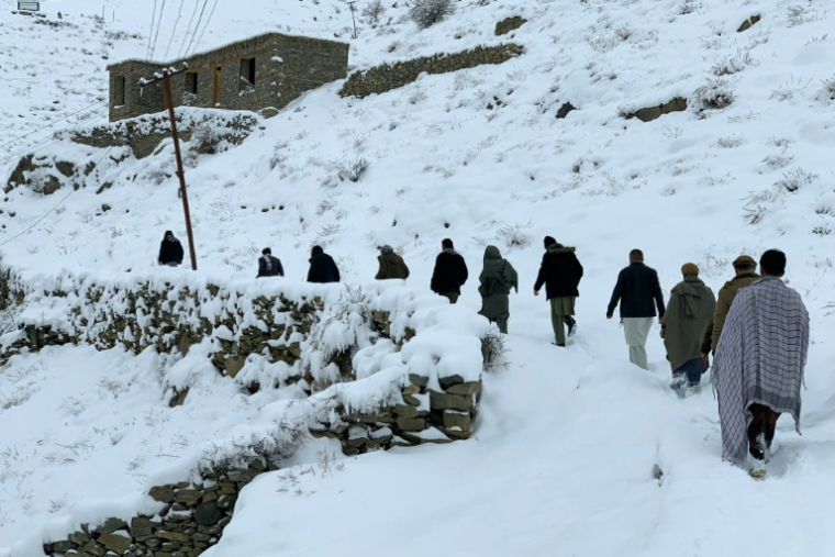 Des Afghans sur un sentier enneigé Afghan dans le district de Dara, dans la   province du Panchir, le 23 janvier 2026  ( AFP / Shah Poor AFZALLY )
