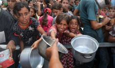 De jeunes palestiniens attendent de recevoir des repas cuisinés dans le camp de réfugiés de Nousseirat, dans le centre de la bande de Gaza, le 18 août 2025 ( AFP / Eyad BABA )