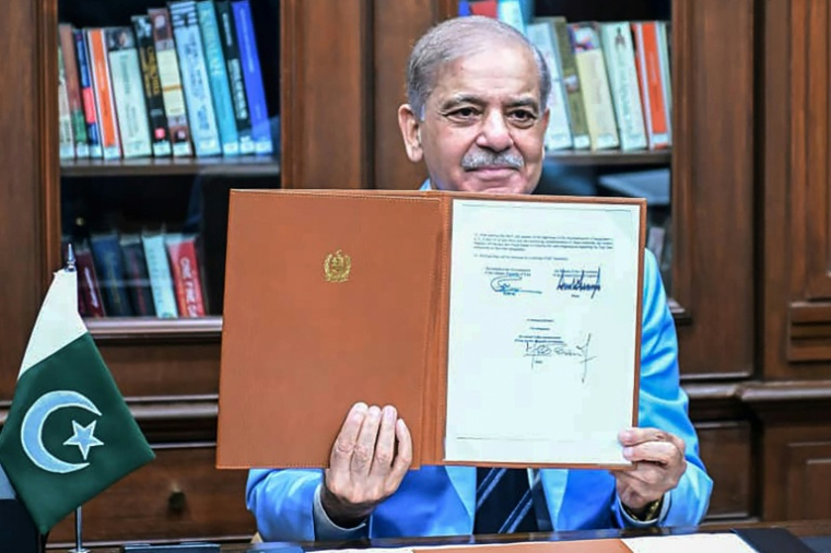 Le Premier ministre pakistanais Shehbaz Sharif montre le protocole d'accord signé par les présidents américain et iranien, après l'avoir lui-même signé en tant que médiateur, le 18 juin 2026 à Islamabad ( Pakistan's Prime Minister Office / - )