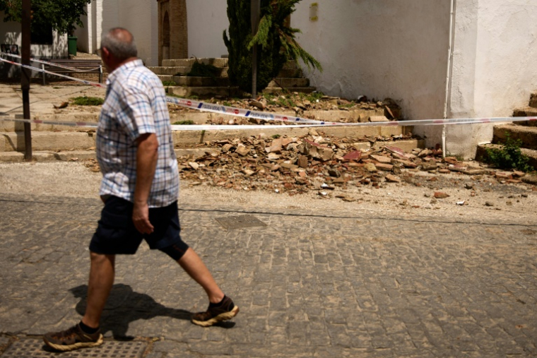 Un homme passe devant des tuiles cassées après un rare séisme de magnitude 5, le 15 août 2026 à Grenade, dans le sud de l'Espagne  ( AFP / Enrique Fajardo )