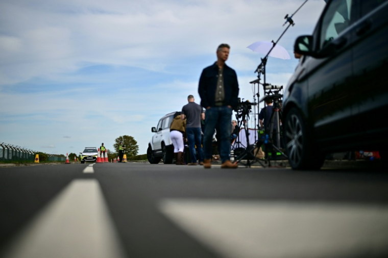 Des journalistes près d'un cordon de police devant la base aérienne de Fairford, le 28 septembre 2026 dans le sud-ouest de l'Angleterre, au lendemain d'une opération de police antiterroriste britannique ( AFP / Ben STANSALL )