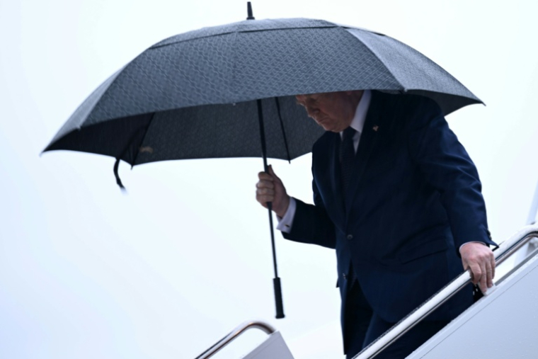 Le président américain Donald Trump tient un parapluie à sa descente de l'avion présidentiel Air Force One à la base Andrews, près de Washington, le 22 mai 2026 ( AFP / Brendan SMIALOWSKI )