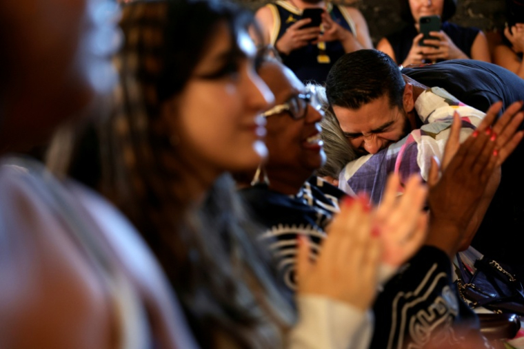 Abdul El-Sayed, candidat à la primaire démocrate dans le Michigan (nord des Etats-Unis), enlace une femme lors d'un meeting de campagne à Détroit, le 3 août 2026 ( AFP / JEFF KOWALSKY )