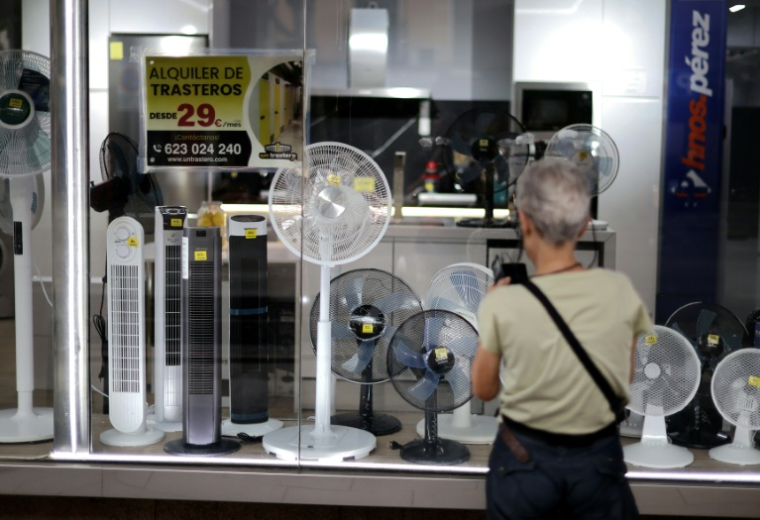Une femme devant un magasin vendant des ventilateurs à Madrid le 25 juin 2026 ( AFP / Thomas COEX )