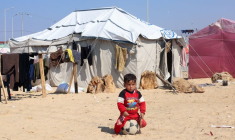 Un garçon palestinien déplacé, qui a fui sa maison à cause des frappes israéliennes, est assis sur un ballon à Rafah