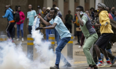 Un manifestant kényan renvoie une grenade lacrymogène vers la police anti-émeute, à Nairobi, le 12 juin 2025 ( AFP / SIMON MAINA )