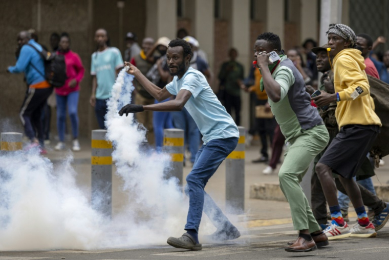 Un manifestant renvoie une grenade lacrymogène vers la police anti-émeute, le 12 juin 2025 à Nairobi, au Kenya ( AFP / SIMON MAINA )