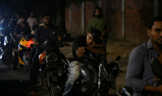 Un homme fait la sieste sur sa moto dans une file d'attente pour du carburant à Dacca, capitale du Bangladesh, le 21 avril 2026 ( AFP / MUNIR UZ ZAMAN )