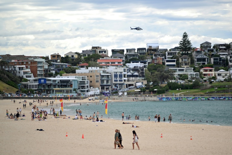 Un hélicoptère de la police patrouille au-dessus de la plage de Bondi le 22 décembre 2025 alors que la vie reprend progressivement après sept jours de deuil qui ont suivi l'attentat antisémite  ( AFP / Saeed KHAN )