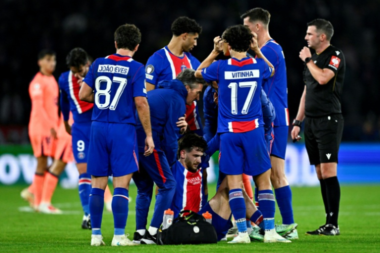 L'attaquant du PSG Khvicha Kvaratskhelia (c) blessé au genou droit lors du match contre le FC Barcelone, le 20 octobre 2026 au Parc des Princes ( AFP / JULIEN DE ROSA )