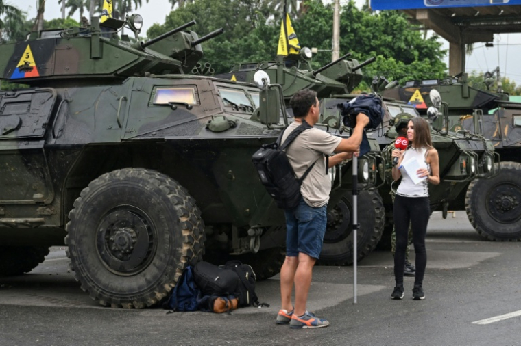 Des journalistes venus du monde entier travaillent à la frontière entre la Colombie et le Venezuela, aux côtés de soldats et de chars militaires, à Villa del Rosario, en Colombie, le 6 janvier 2026 ( AFP / Raul ARBOLEDA )