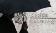 Un homme s'abrite sous un parapluie alors qu'il passe devant la Bourse de Londres