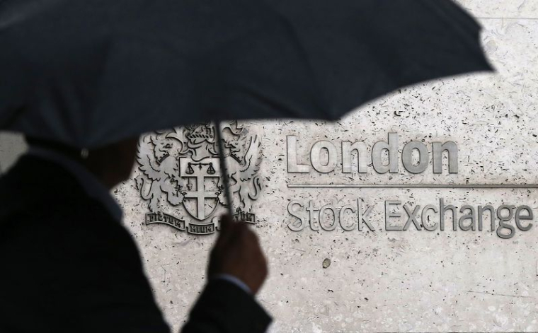 Un homme s'abrite sous un parapluie alors qu'il passe devant la Bourse de Londres