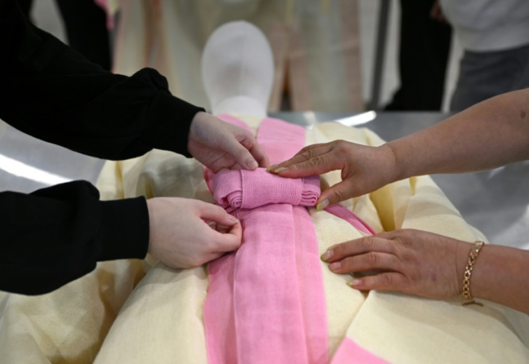 Des étudiants s'entraînent sur un mannequin à revêtir un défunt dans une salle de classe de l'Institut des sciences et technologies de Busan, dans le sud-est de la Corée du Sud, le 24 septembre 2025 ( AFP / Jung Yeon-je )