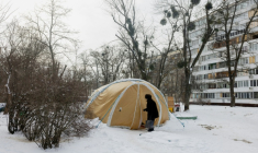 Une femme entre dans une tente proposant des services d'urgence, installée pour les personnes dont les logements sont privés d'électricité ou de chauffage, à Kiev, le 18 février 2026 ( AFP / Tetiana DZHAFAROVA )