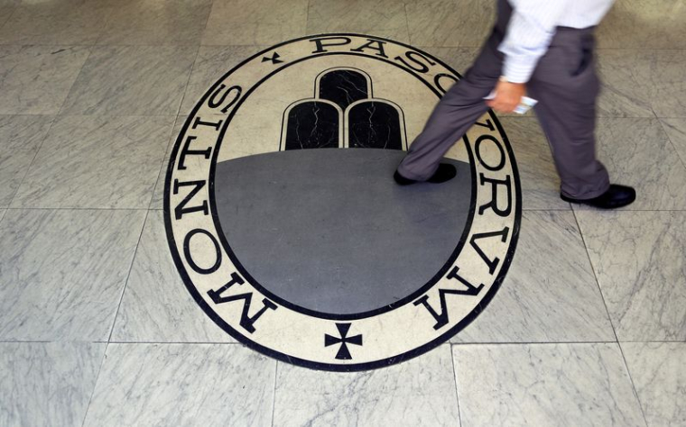 Un homme marche sur le logo de la banque Monte Dei Paschi Di Siena à Rome