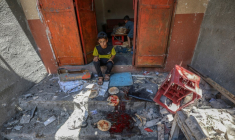 Des enfants palestiniens récupèrent du pain dans une boulangerie détruite par des frappes israéliennes dans le camp de réfugiés de Nousseirat, dans le centre de la bande de Gaza, le 8 mai 2025 ( AFP / Eyad BABA )