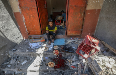 Des enfants palestiniens récupèrent du pain dans une boulangerie détruite par des frappes israéliennes dans le camp de réfugiés de Nousseirat, dans le centre de la bande de Gaza, le 8 mai 2025 ( AFP / Eyad BABA )