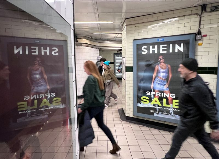 Des personnes passent devant une publicité pour Shein à Londres